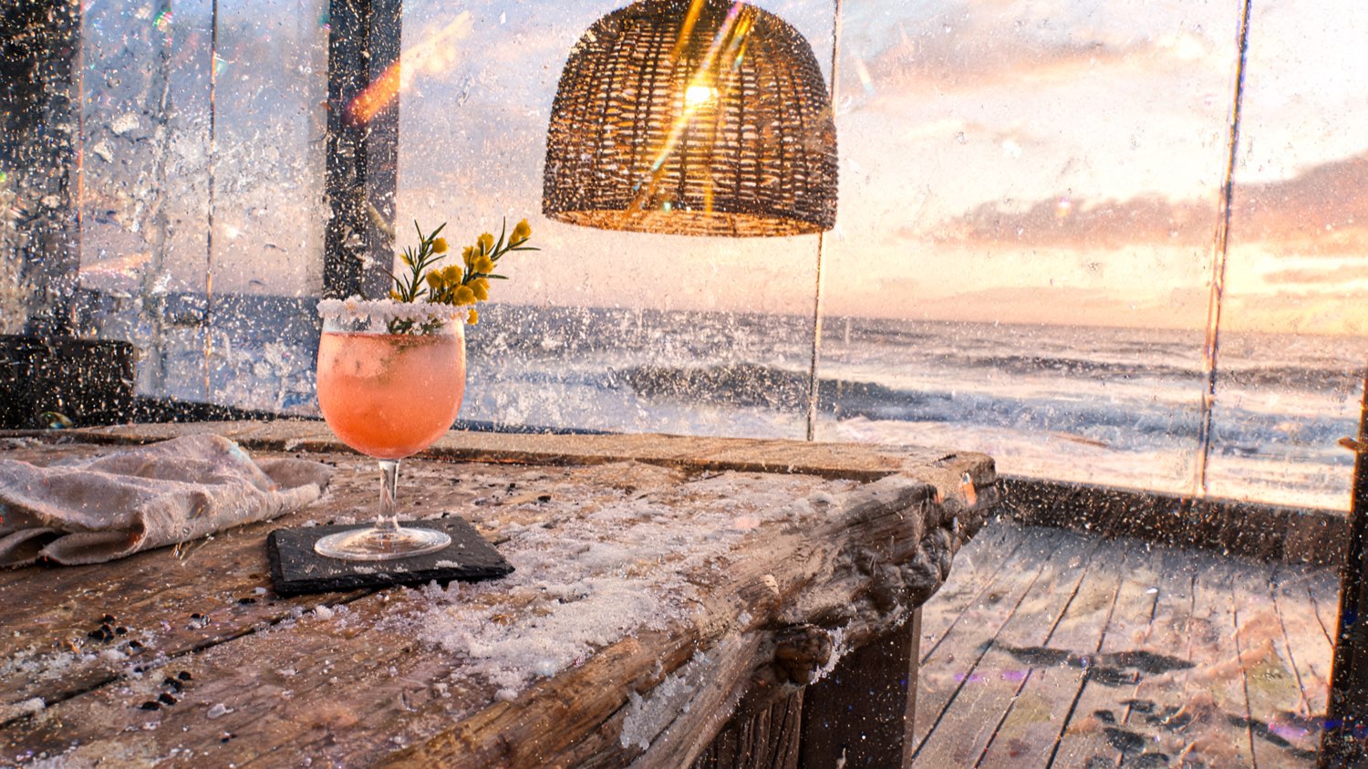 Coastal resort bar detail with a sea-salt-rimmed cocktail on a Cornish slate coaster